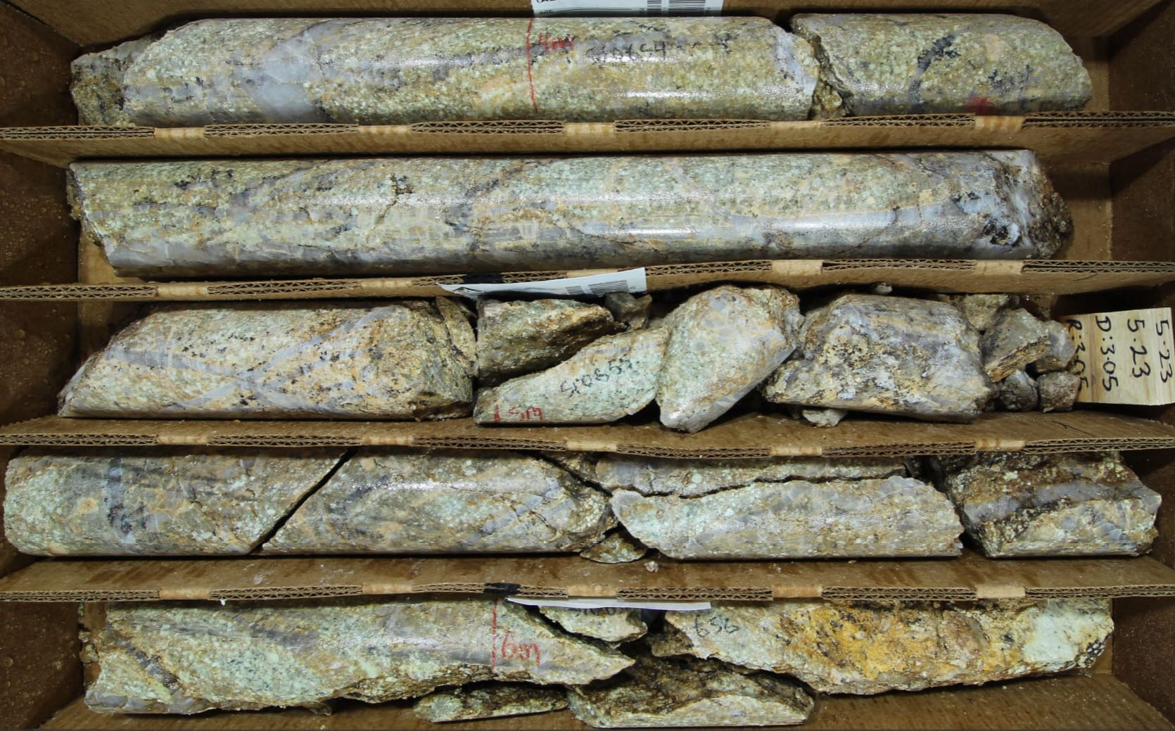 Quartz dacite porphyry with quartz “A-vein” stockworks, with strong potassium feldspar vein alteration selvages, with disseminated and vein-hosted sulfide minerals commonly oxidized to dark limonite spots (Hole 001; 5m; HQ core).